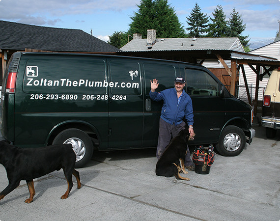 Zoltan waving beside his van with his two dogs and his tool bag